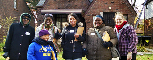 Social Research students and faculty posed in front of a brick home in the Marygrove neighborhood